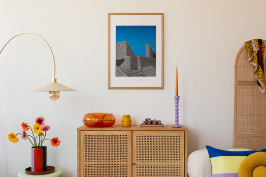 Fototapeta Fresh blooms in bright orange and yellow sit atop a wooden sideboard, framed by geometric decor and a retro glass dish, creating a cheerful modern space. Mock up.