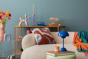 Modern decorative setup with vibrant flowers, a balloon dog sculpture, white sofa and design blue...