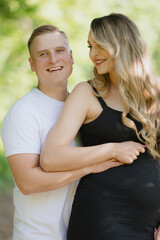 Obraz premium a man is hugging a pregnant woman in a black dress