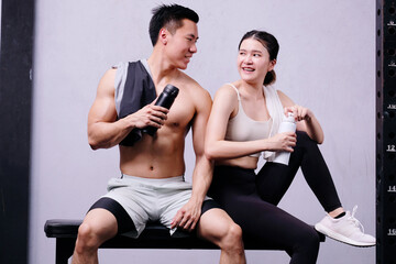 Fototapeta premium Men and women exercising with dumbbells in a fitness gym.