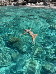 ragazza nuota nel mare trasparente in sicilia 
