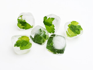 Ice cubes with parsley leaves, white background