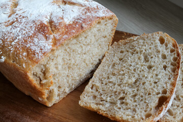 Freshly baked homemade bread in cut form lies on a wooden board. High quality FullHD footage