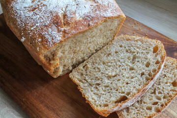 Freshly baked homemade bread in cut form lies on a wooden board. High quality FullHD footage