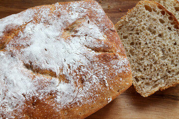 Freshly baked homemade bread in cut form lies on a wooden board. High quality FullHD footage