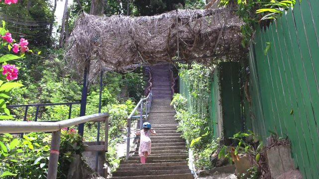 Un b&eacute;b&eacute; fille monte les escaliers vers le point de vue de Ko Phi Phi