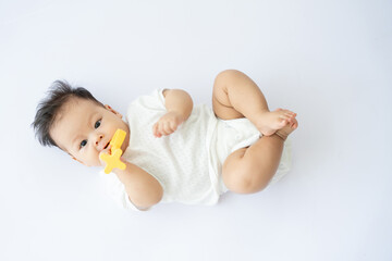 a baby laying on the floor with a paco in his mouth