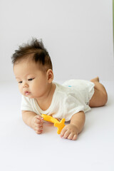 a baby laying on the floor with a toothbrush