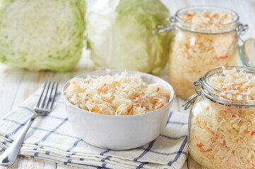 sauerkraut with carrot in a white bowl on the table, selective focus.
