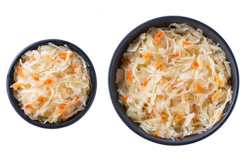 fermented white cabbage with carrot in a black ceramic bowl isolated on white background. Top view.