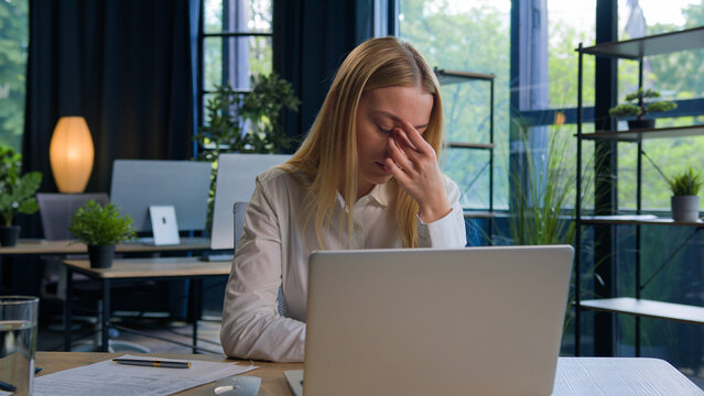 Tired Caucasian woman exhausted overworked business employer businesswoman girl working on laptop feel pain eyestrain dry eyes overload with work stress eyesight discomfort bad vision fatigue headache