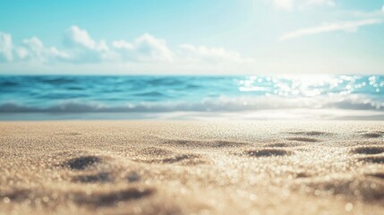 Fototapeta premium Relaxing tropical sandy beach with a soft-focus sea and clear blue sky, ideal for summer visuals.