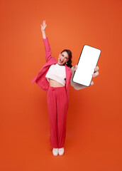 Beautiful business woman showing smartphone mockup of blank screen isolated on orange background. Mobile App Advertisement.