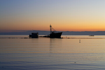 a sunken ship on a beach at sunset in Chile