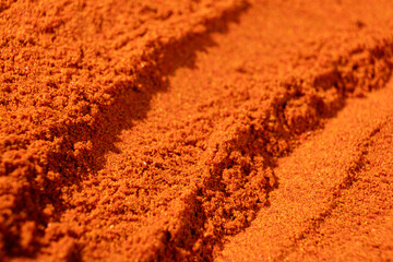 Abstract terracotta striped background of scattered paprika seasoning