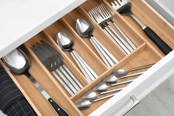 Box with cutlery in drawer, closeup. Kitchen utensils storage