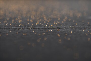 Beautiful shiny golden glitter on black background, closeup