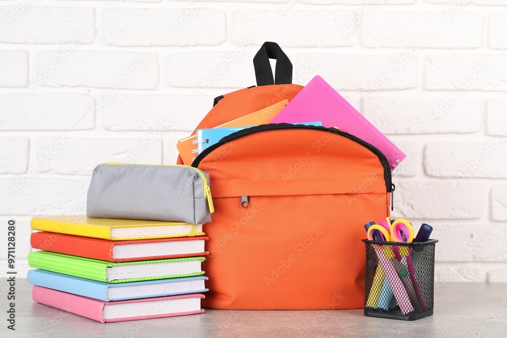 Canvas Prints Backpack with different school stationery on light grey table near brick wall