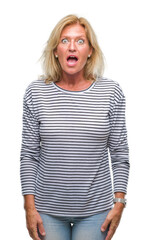Fototapeta premium Middle age blonde woman over isolated background afraid and shocked with surprise expression, fear and excited face.
