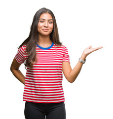 Young beautiful arab woman over isolated background smiling cheerful presenting and pointing with palm of hand looking at the camera.