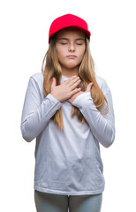 Young beautiful girl wearing red cap isolated background smiling with hands on chest with closed eyes and grateful gesture on face. Health concept.
