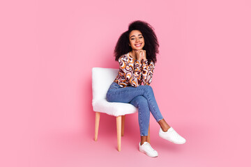 Full length photo of shiny dreamy lady dressed print shirt sitting chair empty space isolated pink...