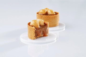 Caramel tart with walnut against white background