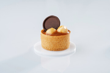 Single caramel tart with walnut against white background