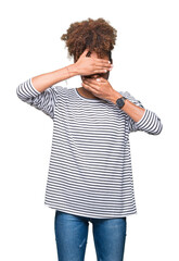 Beautiful young african american woman wearing glasses over isolated background Covering eyes and mouth with hands, surprised and shocked. Hiding emotion