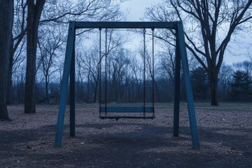 Hauntingly Beautiful Solitary Swing Set in Dimly Lit Park at Dusk - Evoking Nostalgic Childhood Memories and Solitude for Halloween