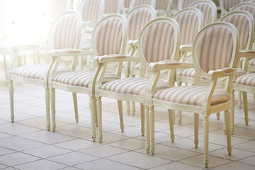 Elegant white chairs with striped upholstery arranged in perfect symmetry, serene and inviting...
