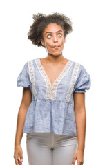 Young afro american woman over isolated background making fish face with lips, crazy and comical gesture. Funny expression.