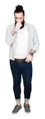 Young man with long hair, beard and earrings smelling something stinky and disgusting, intolerable...