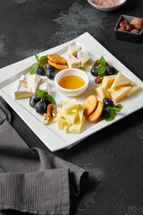 Gourmet Cheese Platter on Dark Slate Surface with Honey and Crackers – High-Contrast Culinary Photography