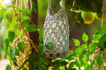 garden lantern wicker made of ropes and glass jar suspended in the garden