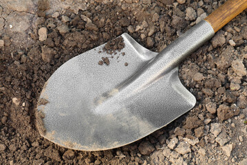 Metal shovel on soil outdoors, closeup. Gardening tool