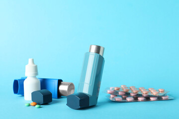 Different asthma medications on light blue background, closeup