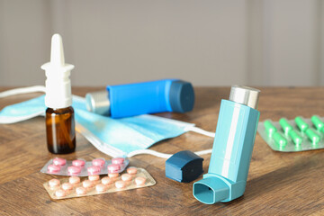Different asthma medications on wooden table indoors, closeup