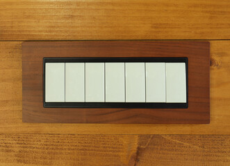 Seven electric switches buttons on wooden wall equipment