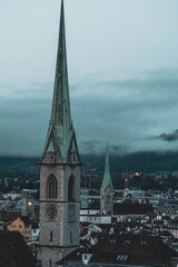 Catholic Church clock tower in a European city. Moody light, summer morning, high vantage point, no...