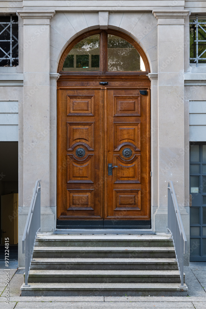 Wall mural Large, old, sculpted and decorated hardwood entrance door in a European city, no people