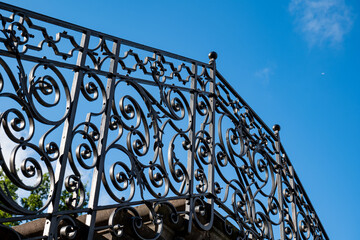 Wrought Iron  balcony railing. Looking up shot, blue sky in the background, no people