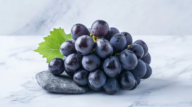 Lots of fresh black grapes on stone, white background.