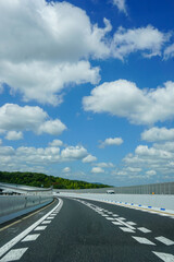 雲畑の夏空の下を走るキレイな道路