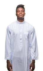 Young arabic african man wearing traditional djellaba over isolated background with serious expression on face. Simple and natural looking at the camera.