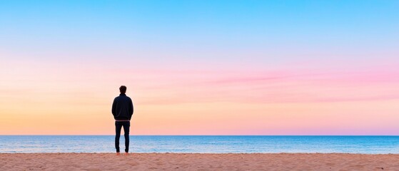 Fototapeta premium Person standing on a beach at dawn, ready to begin a new day
