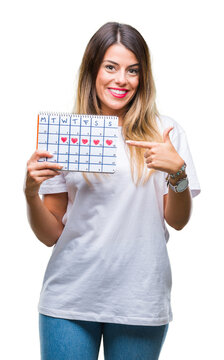 Young beautiful woman holding menstruation calendar over isolated background very happy pointing with hand and finger