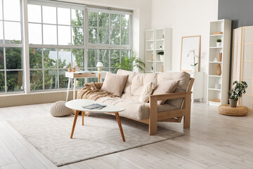 Interior of stylish modern living room with shelving units and beige sofa