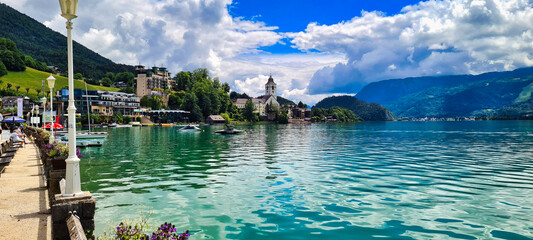 A picturesque view of Wolfgangsee, Austria, with crystal-clear waters, charming lakeside architecture, and the backdrop of lush green mountains. A perfect destination for relaxation, water sports, and