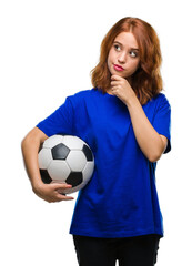 Young beautiful woman over isolated background holding soccer football ball serious face thinking about question, very confused idea